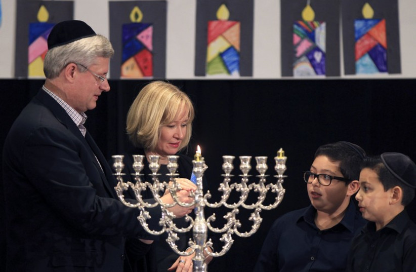 Canada's Prime Minister Stephen Harper (L) and his wife Laureen participate in a candle lighting ceremony to mark the start of Hanukkah in Montreal