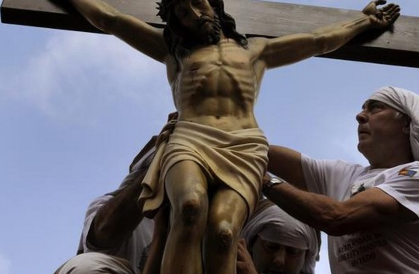 Penitents place a statue of Jesus Christ on top of a float during the Palm Sunday procession of the ''Estudiantes'' brotherhood in Oviedo, northern Spain (credit: REUTERS)