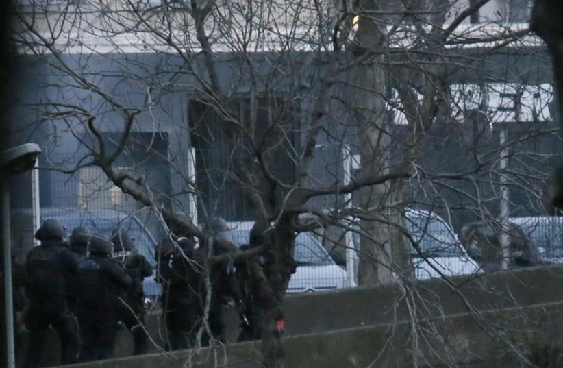 Smoke is seen at left as French police special forces launch their assault at a kosher supermarket (seen at rear) where several people were taken hostage near the Porte de Vincennes in eastern Paris
