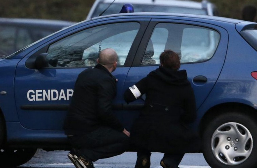 Police take cover during the final assault at the scene of a hostage taking at an industrial zone in Dammartin-en-Goele, northeast of Paris