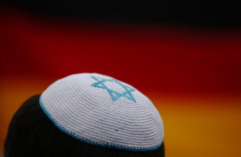 A man wearing a kippah listens to speakers during an anti-Semitism protest at Berlin's Brandenburg Gate (credit: REUTERS)