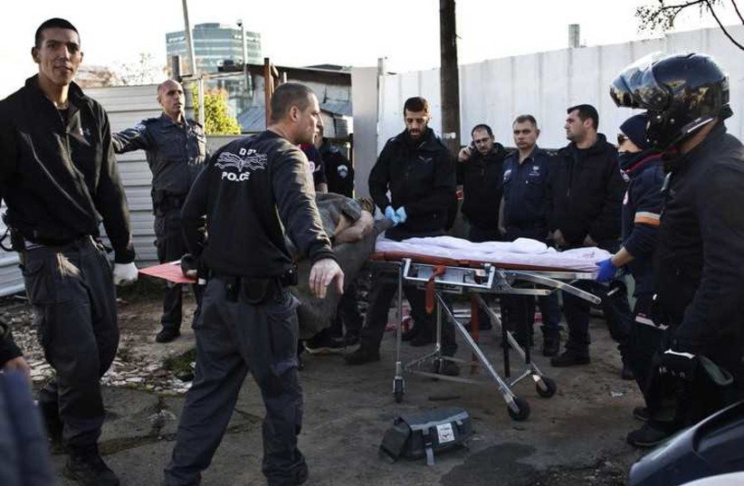 Israeli police officers carry on a stretcher a Palestinian man who stabbed up to 10 people in Tel Aviv.