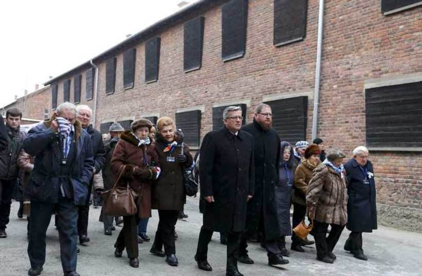 Polish President Komorowski walks with survivors in the former Nazi German concentration and extermination camp Auschwitz.
