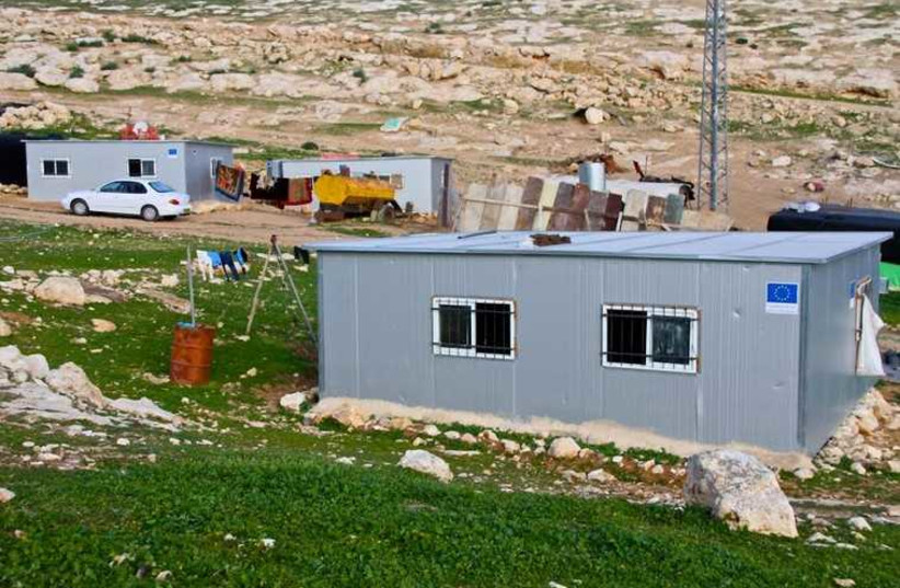 The blue EU logo seen on new modular structures in an illegal Beduin encampment in the Judean hills outside the Ma'alen Adumim settlement.  (credit: TOVAH LAZAROFF)