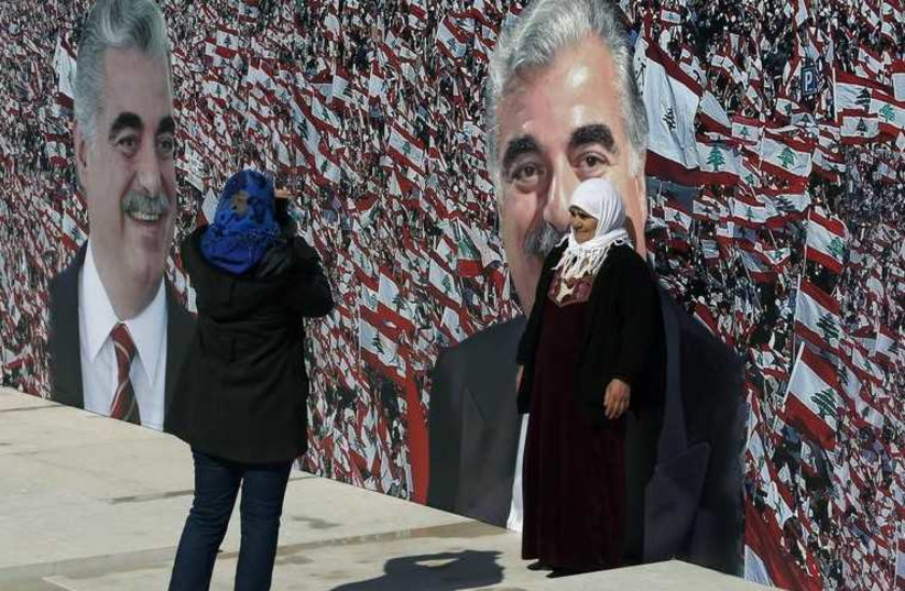 People take a picture near a large banner hanged next to the grave of former Prime Minister Rafik al-Hariri.
