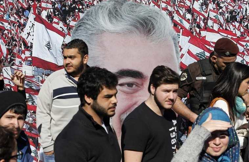 People stand in front of an image of former Prime Minister Rafik al-Hariri.