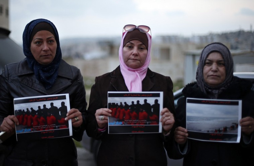 Women hold up pictures of the 21 Egyptian Coptic Christians beheaded by Islamic State in Libya, as they gather in a gesture to show their solidarity, in Amman