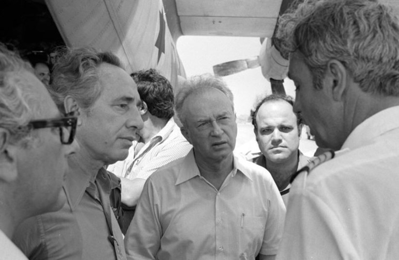 Then-prime minister Yitzhak Rabin (C) and then-defense minister Shimon Peres (2nd L) greet hostages rescued from Entebbe back in Israel