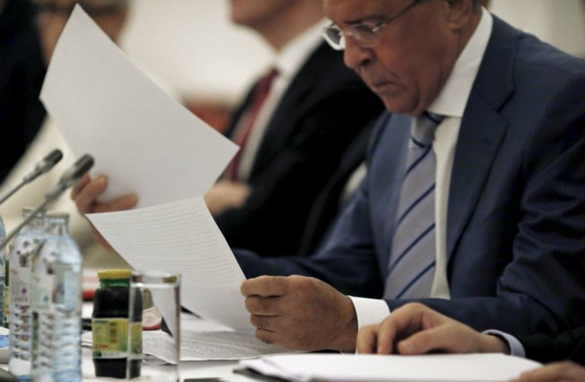 Russian Foreign Minister Sergei Lavrov reads documents during a meeting with foreign ministers and delegations from Germany, France, China, Britain, the U.S. and the European Union at a hotel in Vienna, Austria July 13, 2015.
