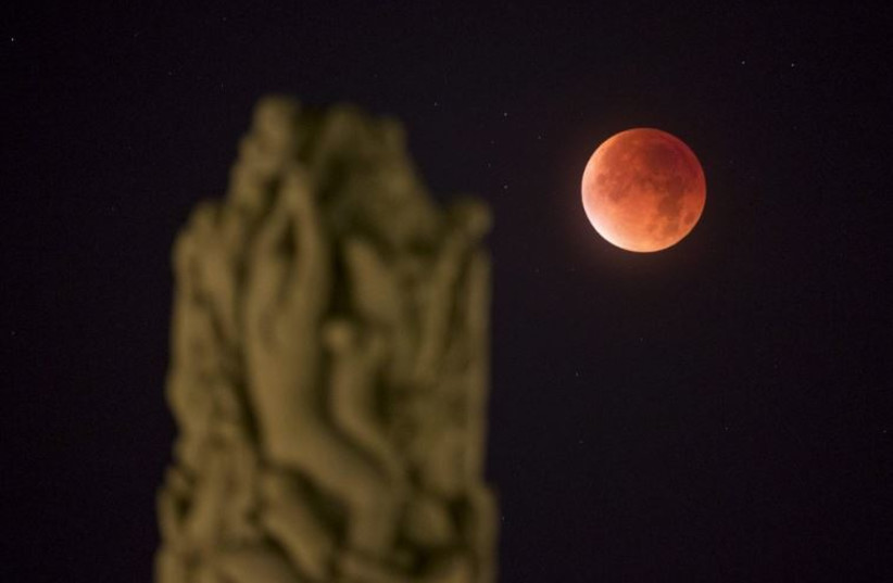 The total ''supermoon'' lunar eclipse is seen from Vigeland Park in Oslo, Norway