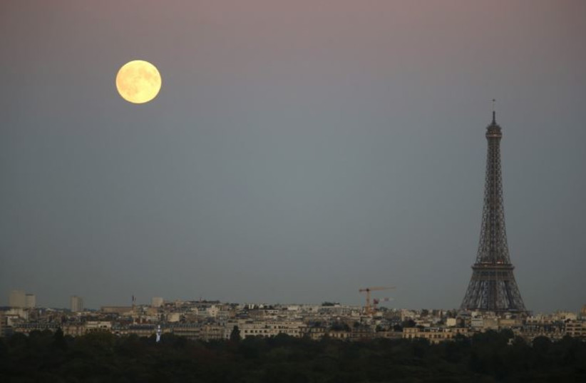 A super moon rises in the sky near the Eiffel tower as seen from Suresnes, Western Paris
