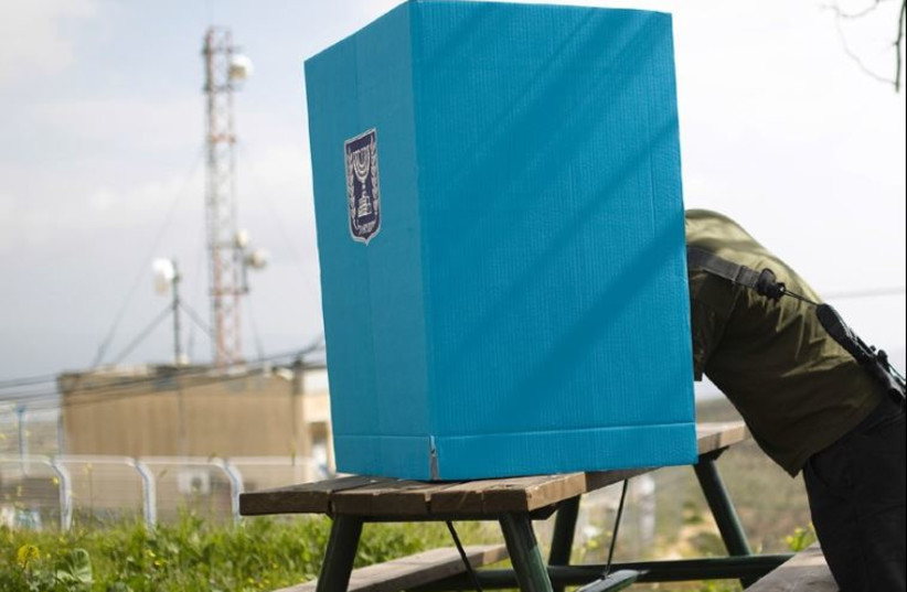 A soldier casts his ballot at a mobile voting booth in the West Bank settlement of Migdalim, March 17