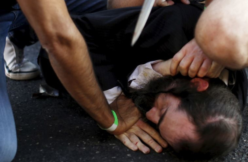 Police disarm an Orthodox Jewish assailant, Yishai Schlissel, shortly after he stabbed six participants at the annual Gay Pride parade in Jerusalem, July 30; Shira Banki, 16, died of her wounds