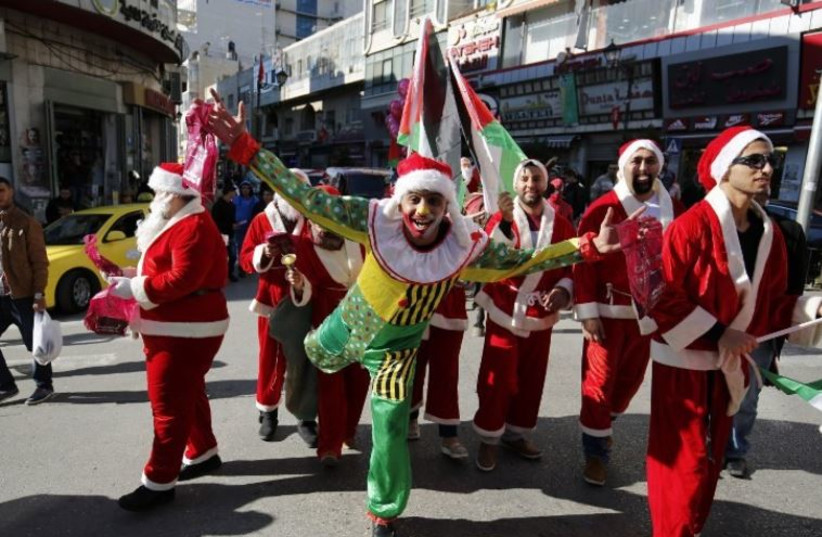 Palestinians dressed up as Santa Claus distribute gifts on a street in the West Bank city of Ramallah