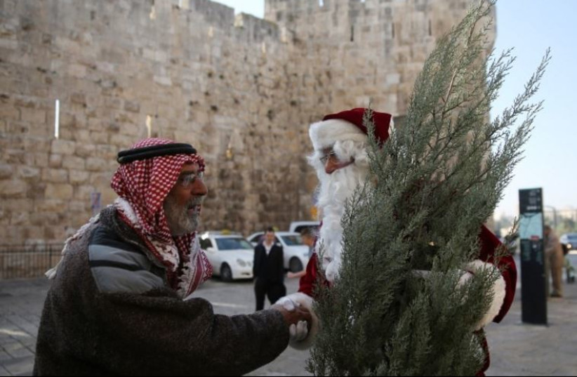 A Christian man dressed up as Santa Claus greets a Muslim man in Jerusalem's Old City