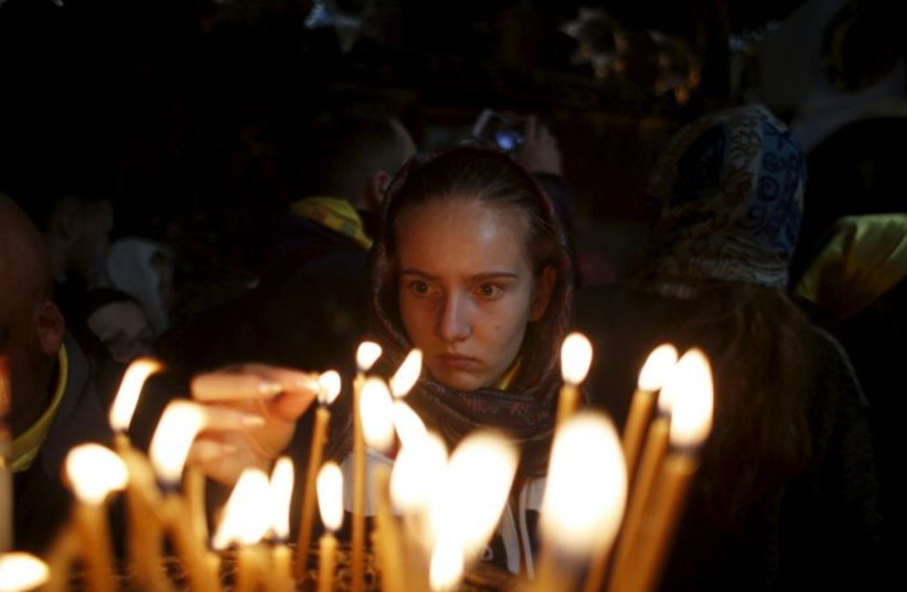 A worshiper lights candles inside the Church of Nativity, ahead of Christmas in the West Bank city of Bethlehem