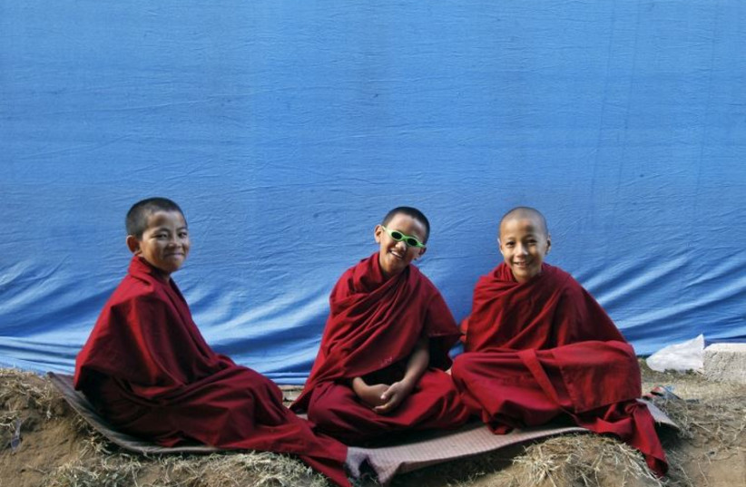 Novice Buddhist monks react to the camera during the Jangchup Lamrim teachings in Karnataka, India