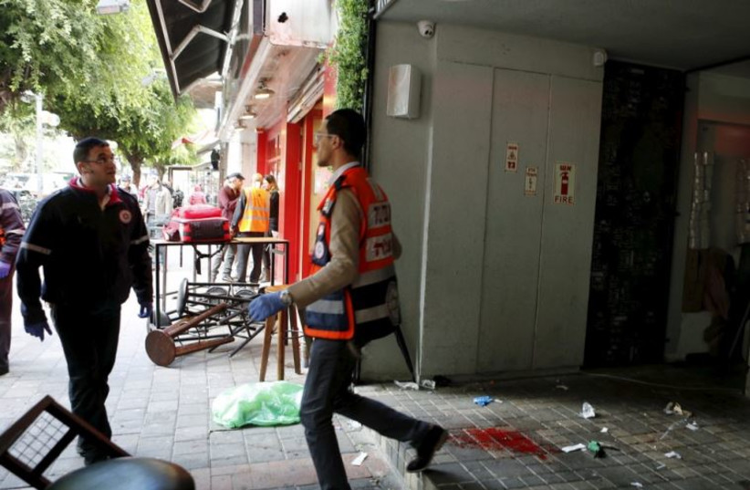 Rescue personnel walk next to blood stains at the scene of a shooting incident in Tel Aviv
