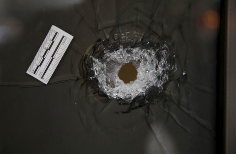 A bullethole is seen in the window of a restaurant at the scene of a shooting incident in Tel Aviv