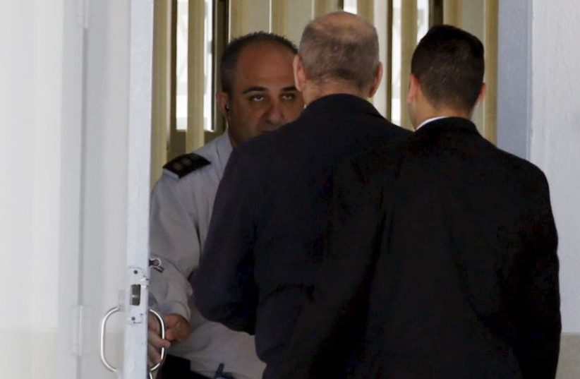 Former prime minister Ehud Olmert (C) enters Ma'asiyahu prison near Ramle