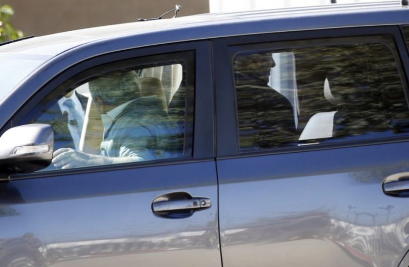 Former prime minister Ehud Olmert (R) steps out of a car just before entering Ma'asiyahu prison near Ramle
