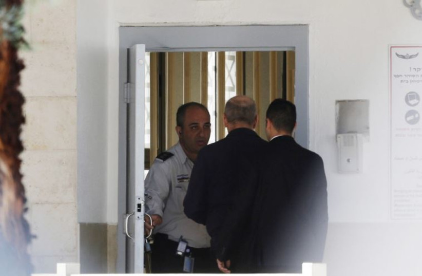 Former prime minister Ehud Olmert (C) enters Ma'asiyahu prison near Ramle