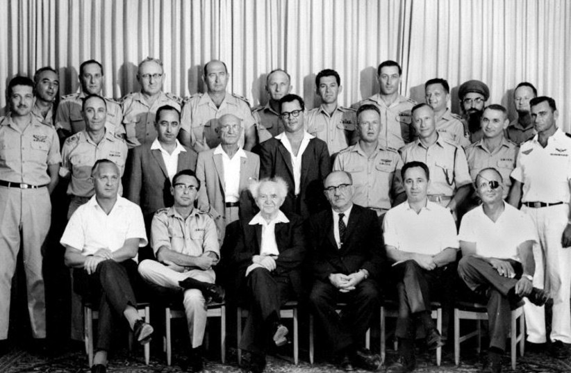 THEN-DEFENSE MINISTRY director-general Shimon Peres (seated second right) attends a meeting of the IDF General Staff with prime minister David Ben-Gurion in 1961. Peres is sitting between then-finance minster Levi Eshkol and then-agriculture minister Moshe Dayan