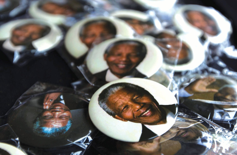 PINS DEPICTING former South African President Nelson Mandela are displayed for sale at a memorial service held by the African National Congress (photo credit: REUTERS)