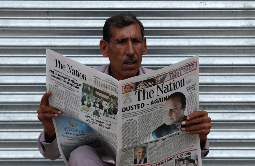 MAN in Pakistan reads a newspaper with news about the disqualification of Pakistani Prime Minister Nawaz Sharif by the Supreme Court.. (photo credit: REUTERS)