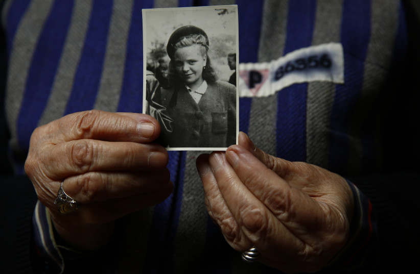 Auschwitz death camp survivor Jadwiga Bogucka holds a picture of herself from 1944 in Warsaw (photo credit: KACPER PEMPEL / REUTERS)