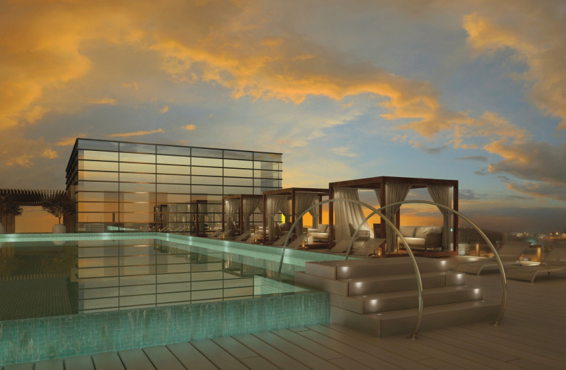The rooftop pool of the Isrotel glistening at sunset.