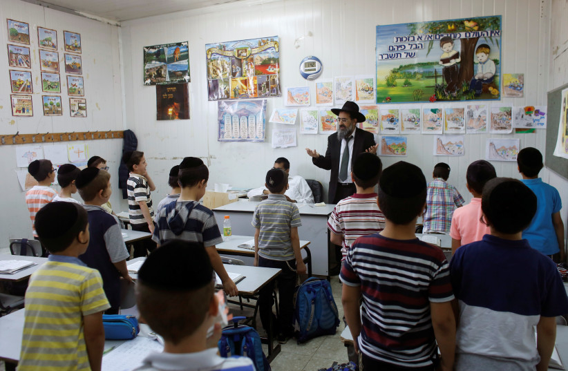 Students and a rabbi at an ultra-orthodox school in B'nei Brak, July 2017 (credit: NIR ELIAS / REUTERS)
