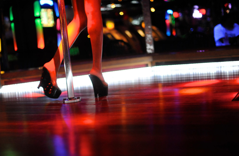 A dancer performs for customers at a strip club (photo credit: BRIAN BLANCO / REUTERS)
