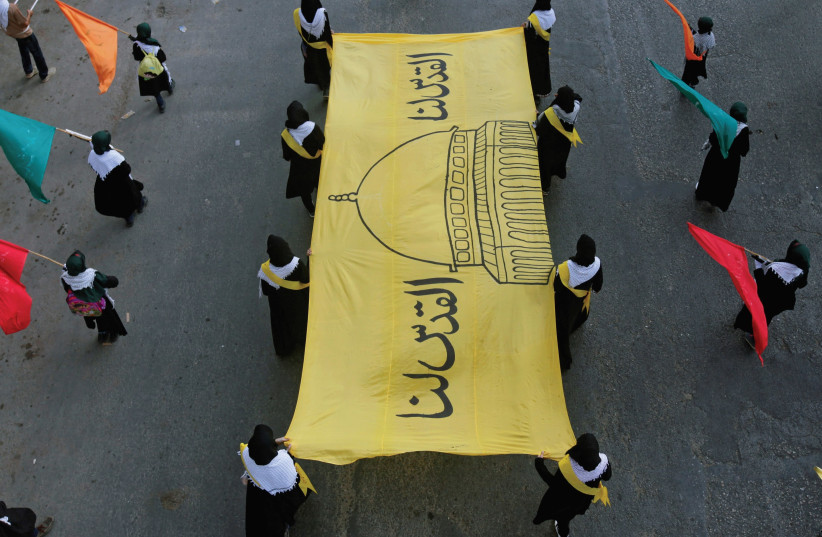 Muslims in Pakistan carry a banner with an image of the Dome of the Rock during a march to commemorate Jerusalem and protest Israel. (photo credit: REUTERS)