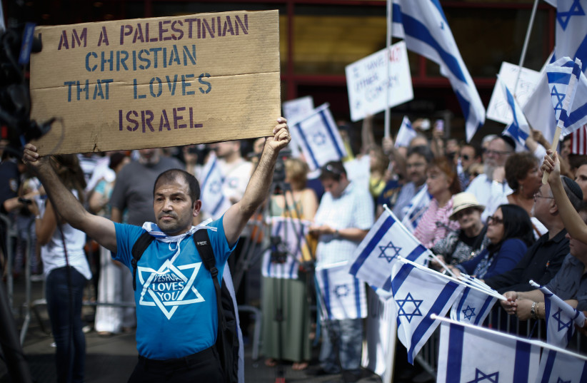 A pro-Israel supporter holds up a sign during a rally at Times Square in New York (photo credit: REUTERS/EDUARDO MUNOZ)