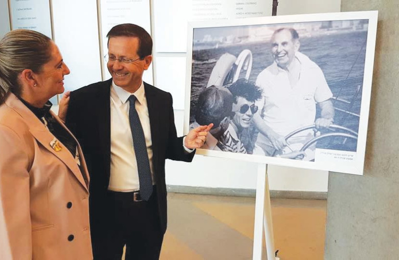 Michael and Isaac Herzog look at a photo of his father, Israel’s sixth president Chaim Herzog, indulging in his favorite sport – sailing. (photo credit: FACEBOOK)