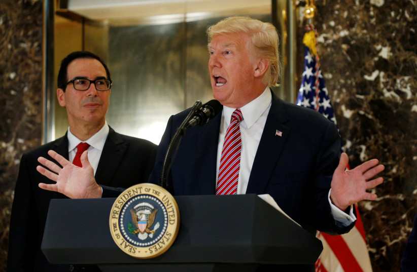 U.S. President Donald Trump answers questions about his responses to the deaths and injuries at the "Unite the Right" rally in Charlottesville as he talks to the media with Treasury Secretary Steven Mnuchin (L) at his side in the lobby of Trump Tower in Manhattan, New York, U.S., August 15, 2017. (photo credit: KEVIN LAMARQUE)