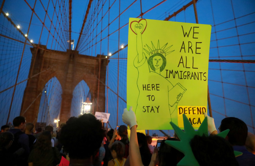 People march across the Brooklyn Bridge to protest the planned dissolution of DACA (photo credit: STEPHEN YANG / REUTERS)