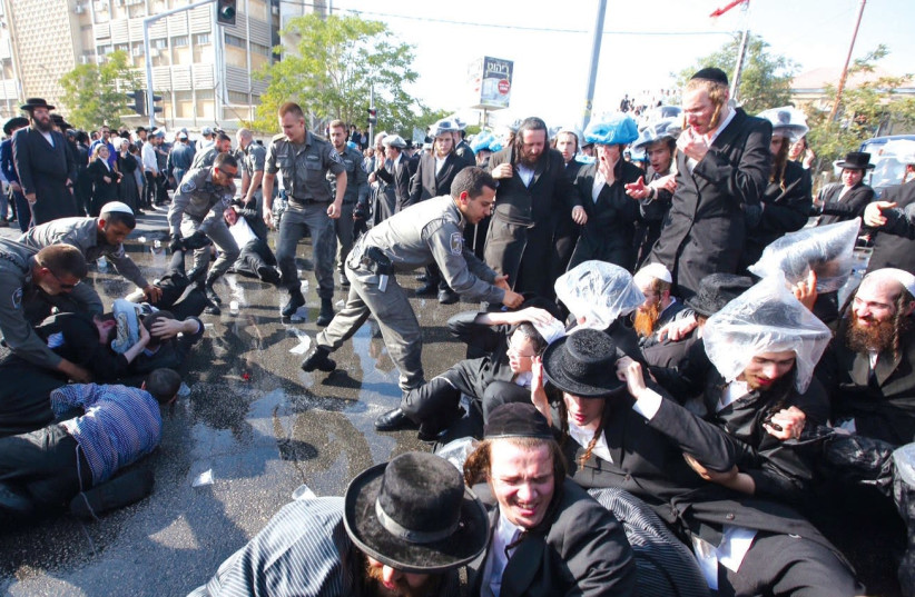 BORDER POLICE OFFICERS detain ultra-Orthodox protesters on Sunday during a draft riot in Jerusalem. (photo credit: MARC ISRAEL SELLEM/THE JERUSALEM POST)