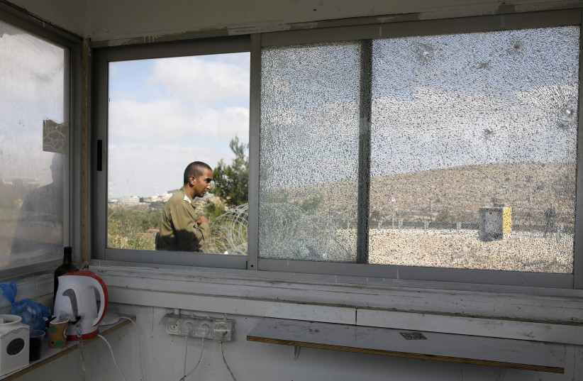 IDF soldier outside location of terror shooting at a security booth in West Bank town of Har Adar, September 26, 2017.  (photo credit: MENAHEM KAHANA / AFP)