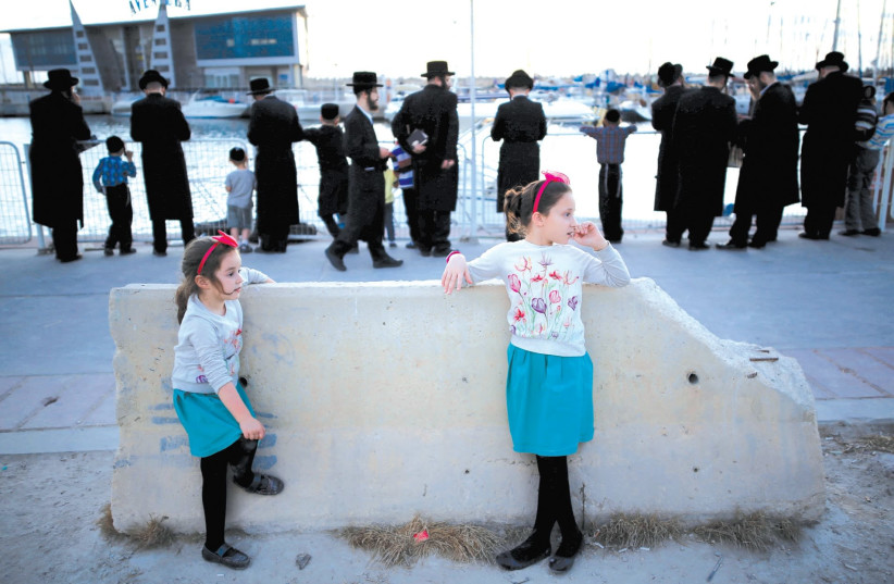 WORSHIPERS TAKE part in ‘tashlich’ (ritual of casting away sins of the past year into the water) ahead of Yom Kippur on the seashore in Ashdod, last year. (photo credit: AMIR COHEN - REUTERS)