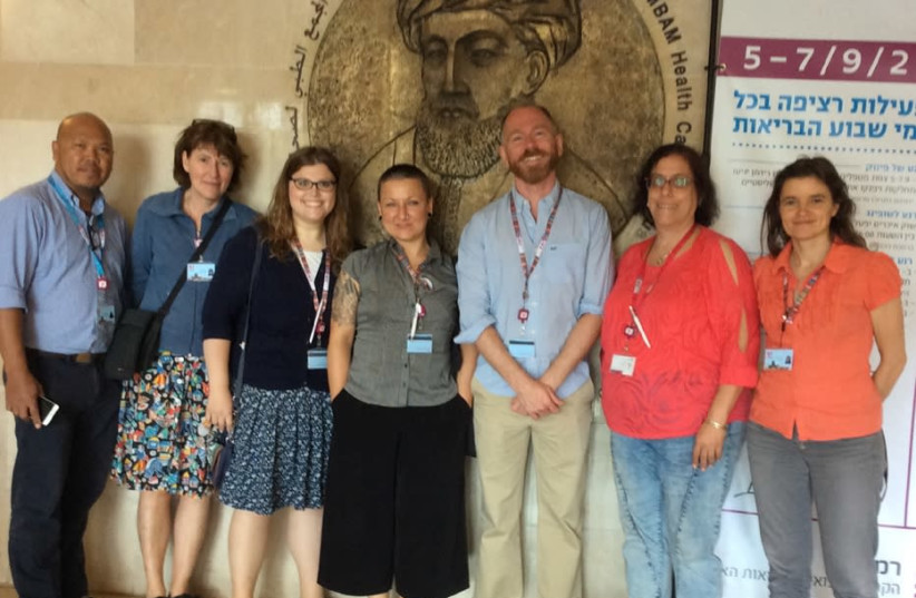 The group from Homerton Hospital stands in front of the plaque of Maimonides at Rambam Medical Center. (photo credit: WENDY BLUMFIELD)