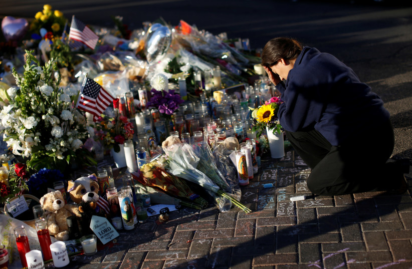 A woman pauses at a makeshift memorial in the middle of Las Vegas Boulevard following the mass shooting in Las Vegas, Nevada, US, October 6, 2017. (photo credit: REUTERS)