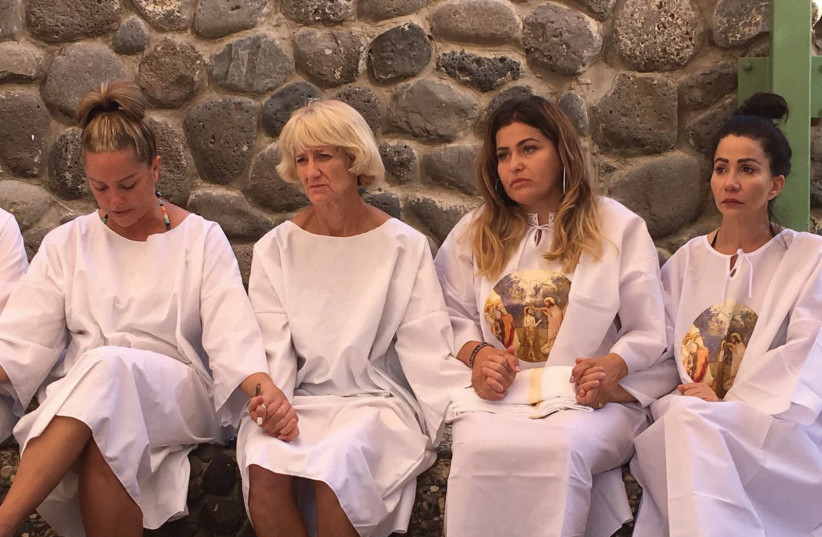 Rocio Villanueva, 31, of Escondido, California (second from the right), joins hands with other US women veterans prior to being baptized in the Jordan River (photo credit: COURTESY HEROES TO HEROES)