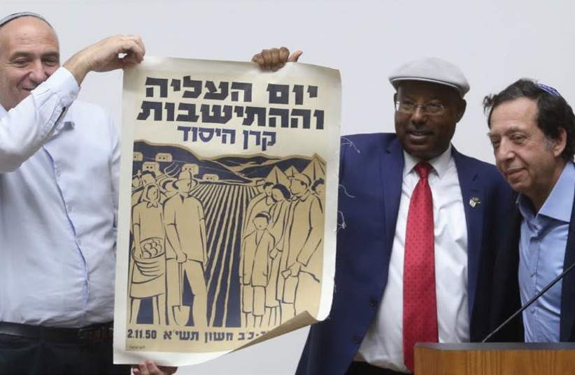 Mark Eisenberg, from the French olim organization Qualita, gives an original poster from 1950 to MK Avraham Neguise at the Knesset yesterday. MK Moti Yogev helps display the poster, which says ‘Aliya and Settlement Day – Keren Hayesod.’ (photo credit: MARC ISRAEL SELLEM/THE JERUSALEM POST)