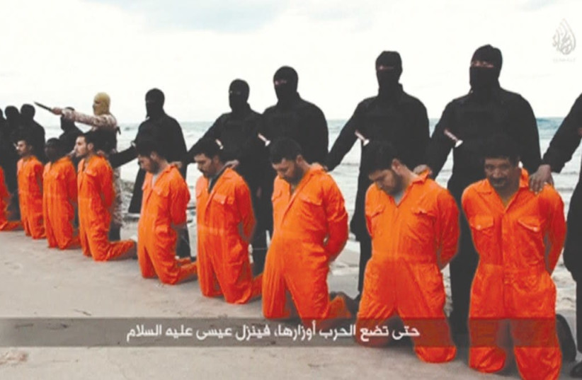 A STILL IMAGE from a video shows men, purported to be Egyptian Christians held captive by Islamic State, kneeling before armed men on a beach in Tripoli, Libya, in 2015. (photo credit: REUTERS)
