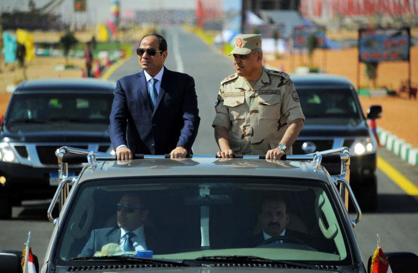Egyptian President Abdel Fattah al-Sisi (L) rides a vehicle with Egypt's Minister of Defense Sedki Sobhi during a presentation of combat efficiency and equipment of the armed forces in Suez, Egypt, October 29, 2017 in this handout picture courtesy of the Egyptian Presidency. (photo credit: THE EGYPTIAN PRESIDENCY/HANDOUT VIA REUTERS)