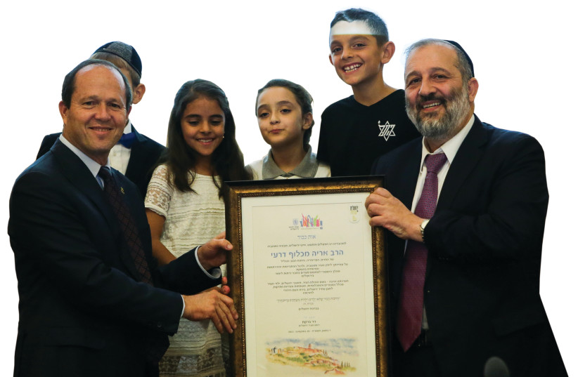 Mayor Nir Barkat (left) and Interior Minister Arye Deri (right) pose with local children at a festive city council meeting that offered thanks to Deri for the special loan to build schools and classrooms for the city’s pupils.  (photo credit: OREN BEN HAKON)