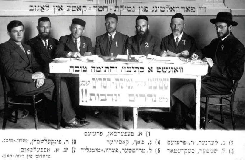 The photograph of a meeting of the Executive Committee of the Gemillus Chasodim (Help for the Needy) Fund of Lagow that appears on the back of a New Year's greeting postcard circa 1937 (photo credit: Courtesy)