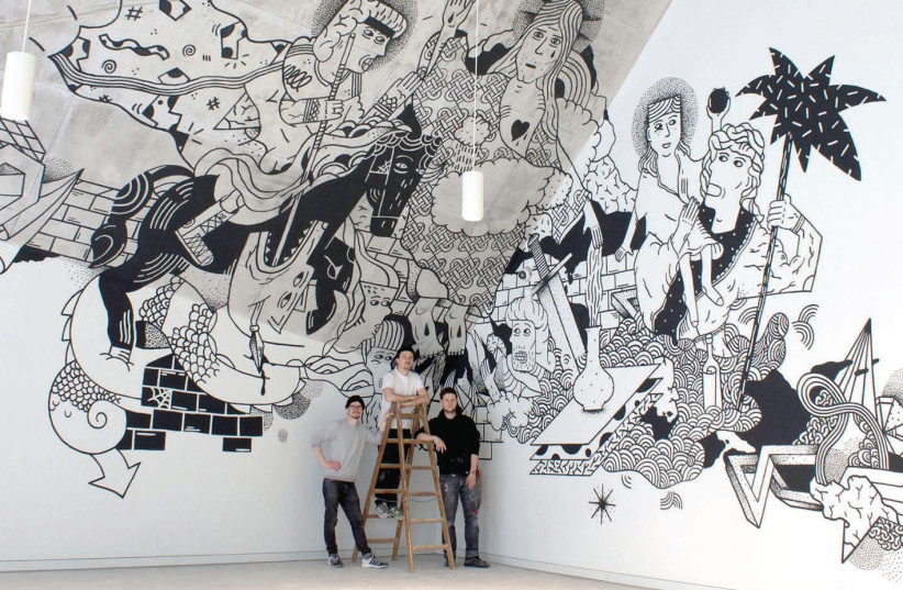 Three of the Klub7 artists are dwarfed by one of their large-scale murals. (photo credit: KLUB7)